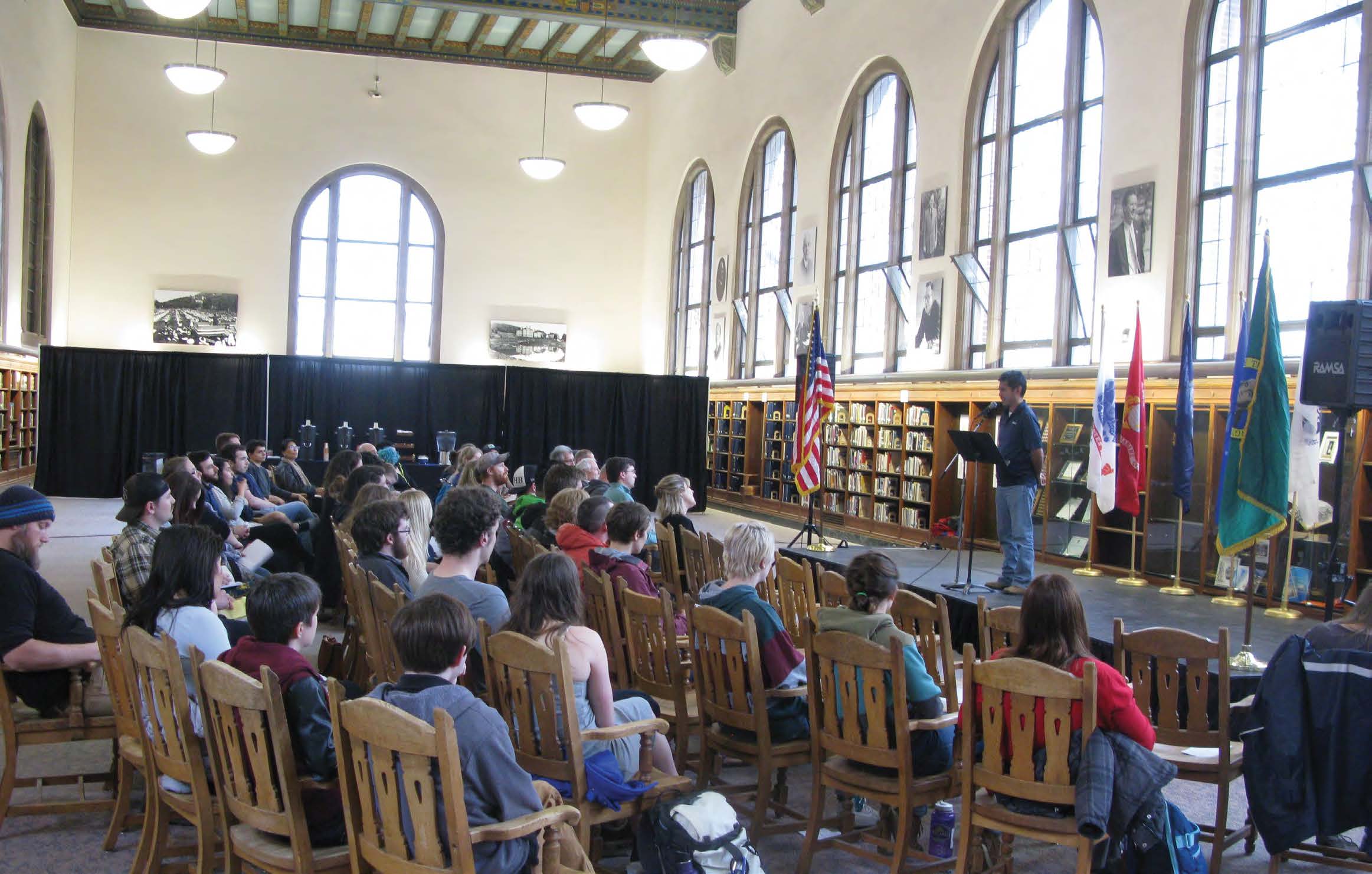 A presenter on stage in a library